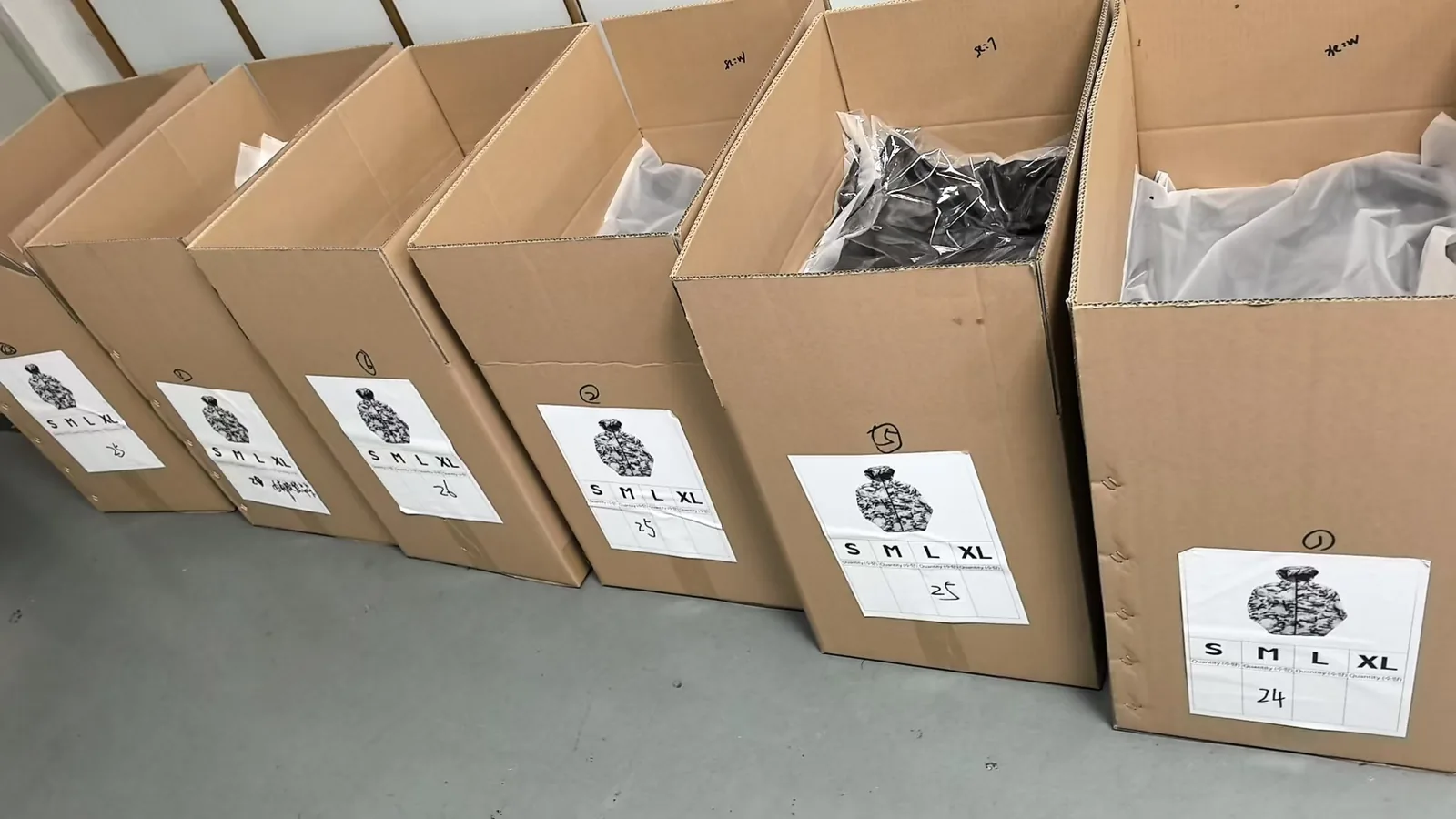 Cartons of windbreakers packed by size and lined up