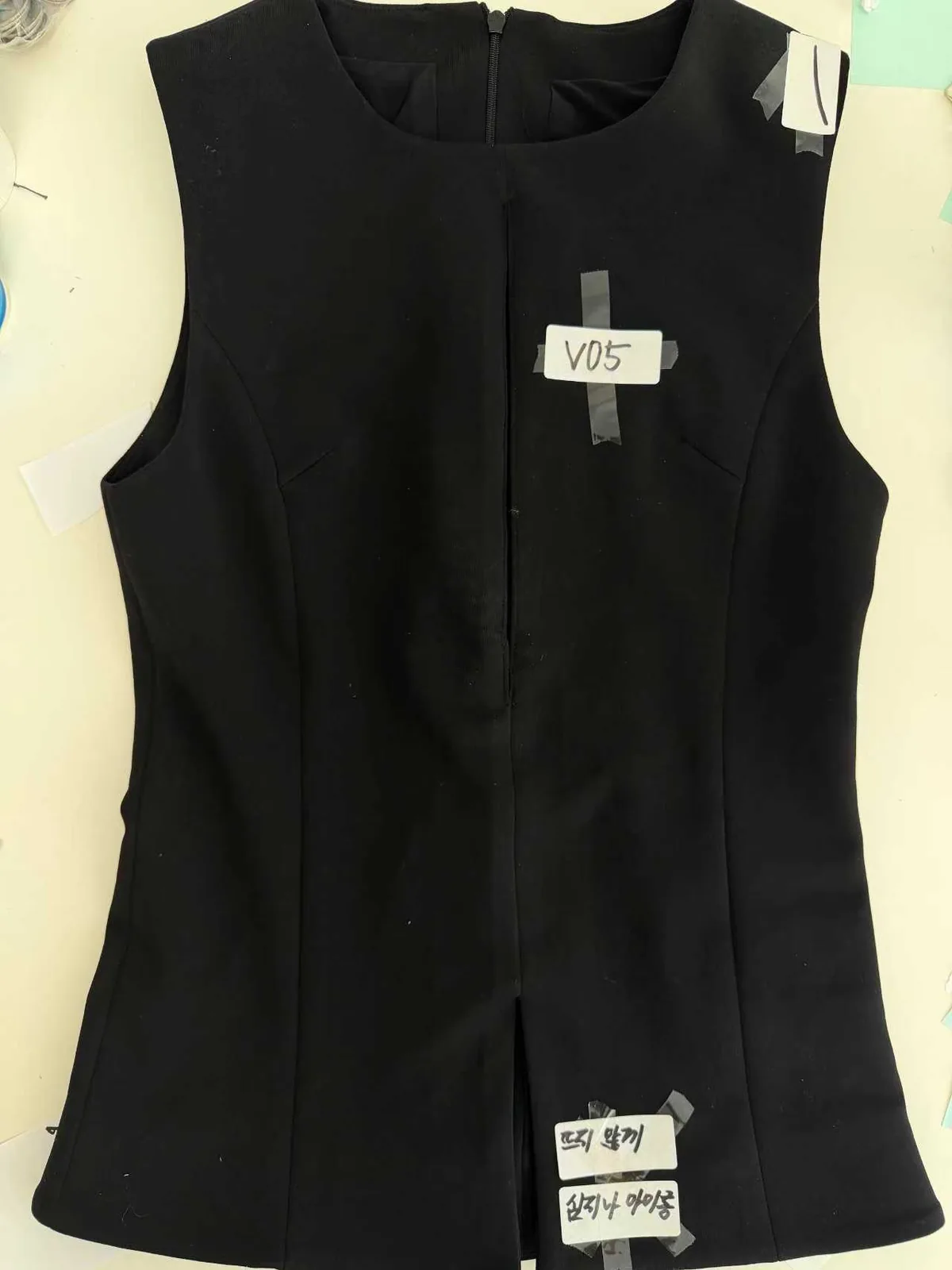 Black sleeveless top sample with fit notes taped on